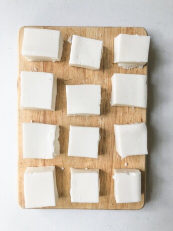 overhead view of squares of haupia on a wood cutting board
