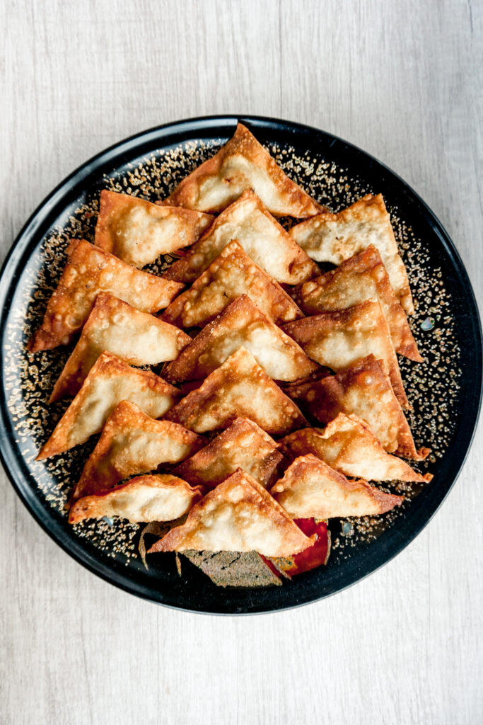 Round platter with fried triangle shaped Japanese wontons