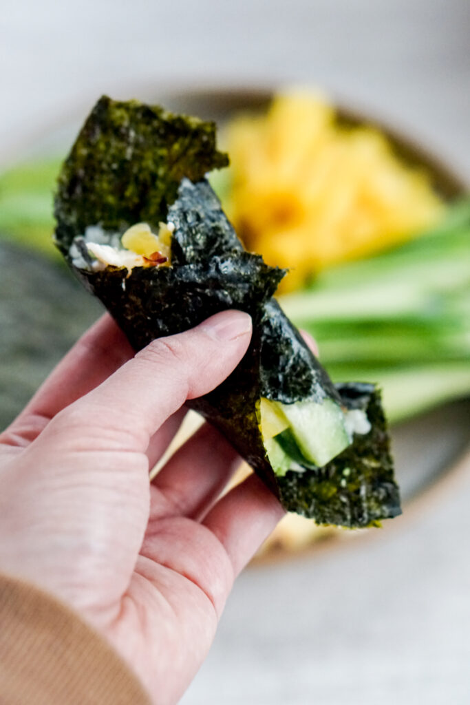 Closeup of rolled seaweed with sushi bake inside.
