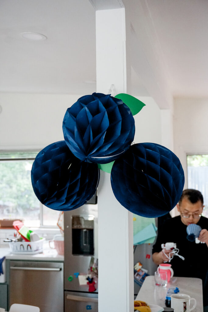 DIY blueberry garland party decorations made from paper honeycomb balls 