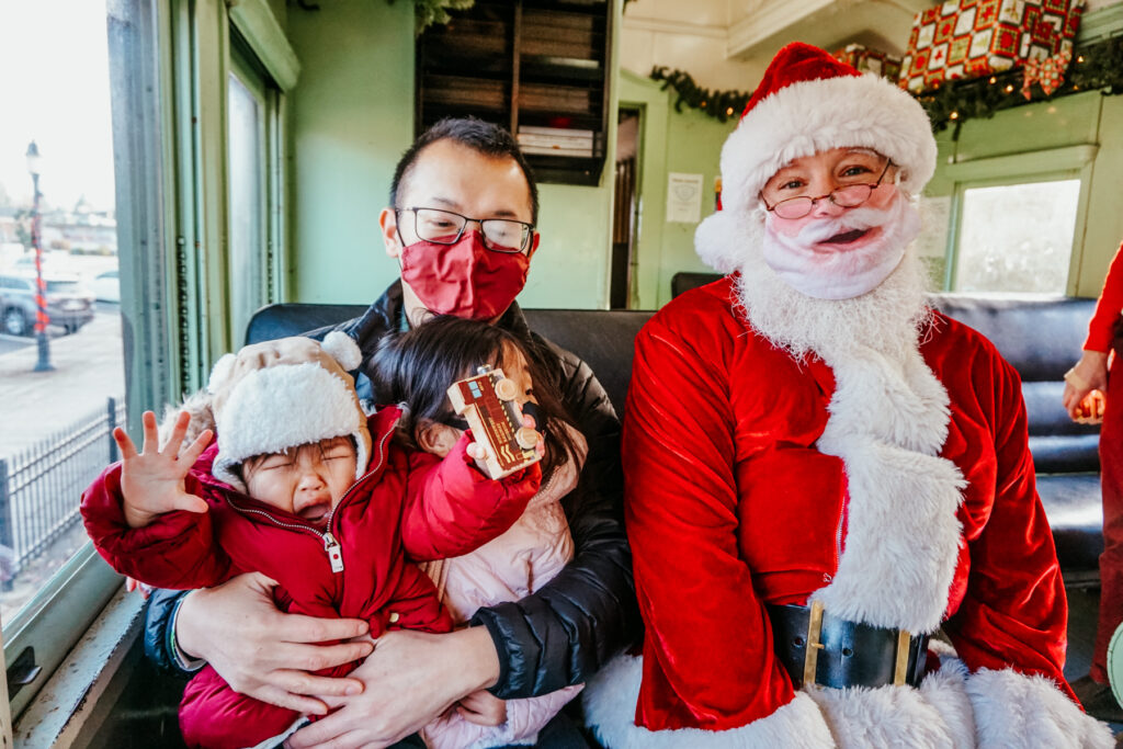 Crying baby with Santa on a train