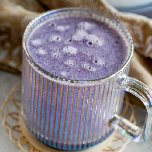 purple sweet potato latte in a clear glass cup